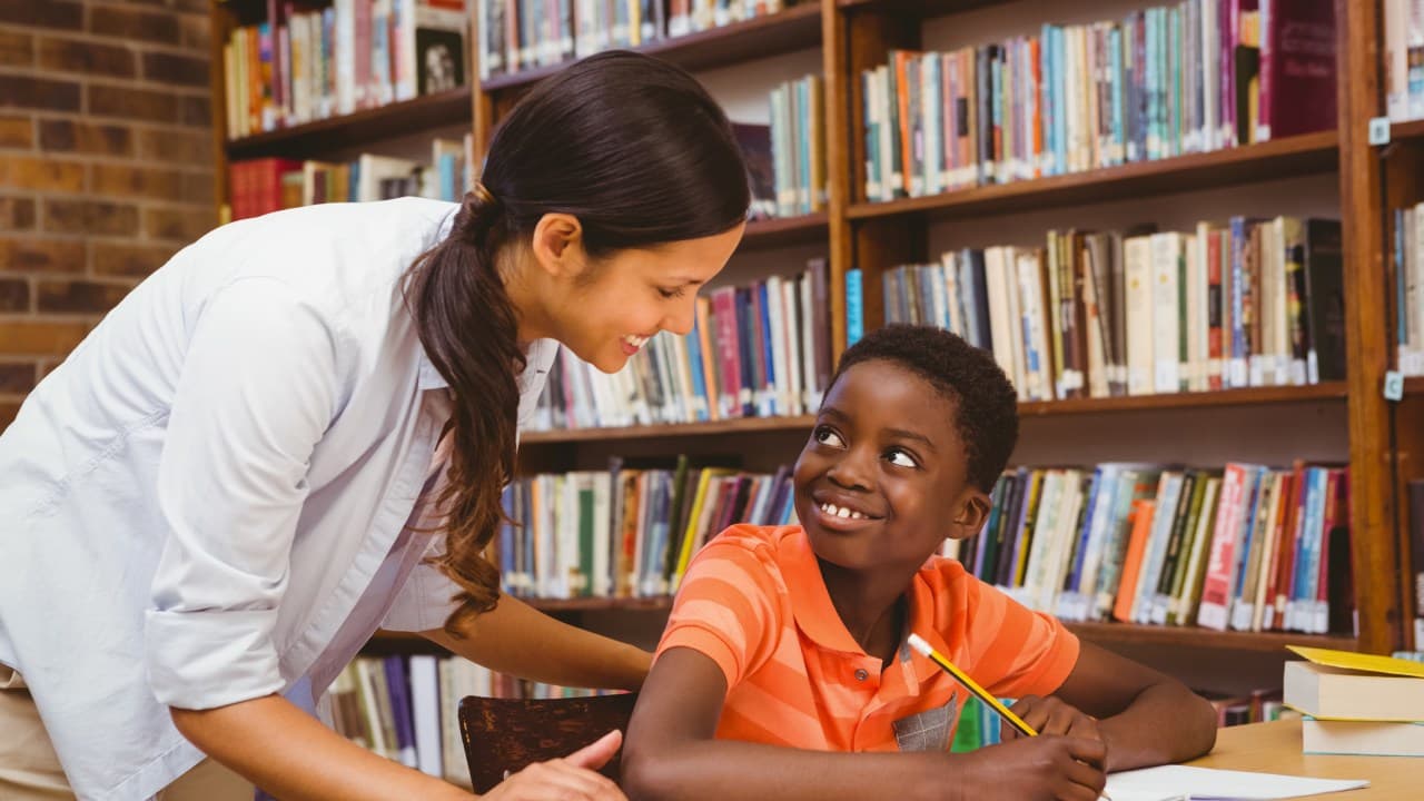 Young kid being tutored in library